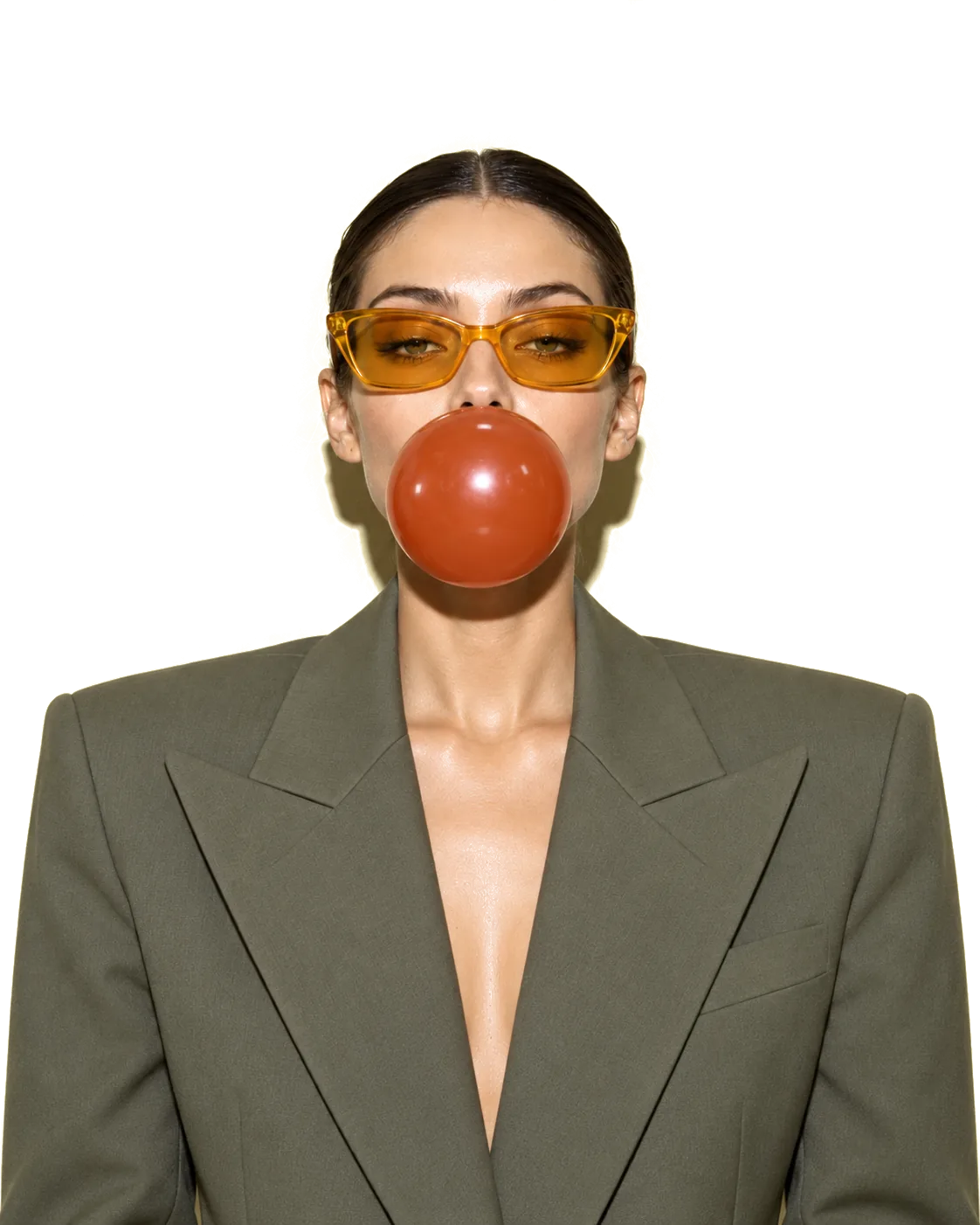 Retrato de frente, com óculos alaranjados, a fazer uma bola de pastilha elástica